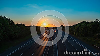 Sun setting over a empty motorway M40 with reduced traffic due to COVID-19 Stock Photo