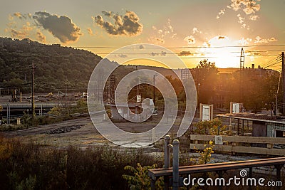 Sun setting over remains of abandoned vintage factory being torn down Stock Photo