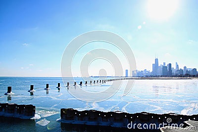 Sun shines bright over Chicago skyline and a frozen Lake Michigan in winter Stock Photo