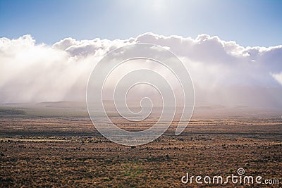 Sun shines over low clouds above vast and empty land along Volcanic Loop Hwy and Desert Road. Central Plateau, New Stock Photo