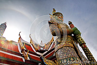 Sun shines through the roof of a temple and a Thai giant guarding a temple in Bangkok,Thailand. Stock Photo