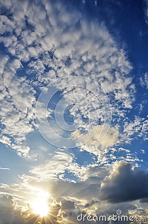 Sun shining through dynamic clouds. Stock Photo