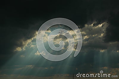 Sun shinning through storm cloud Stock Photo