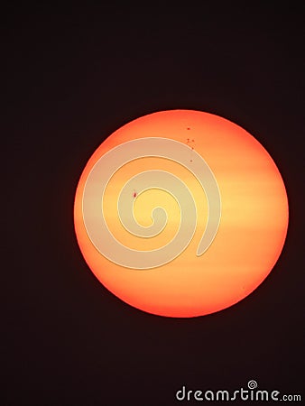 Sun visible through smoke haze showing giant sunspots. Stock Photo
