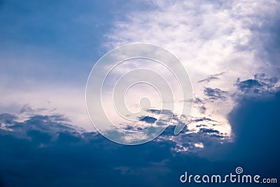 The sun started to shine with orange rays of light in the cloudy sky after the big thunderstorm. Stock Photo