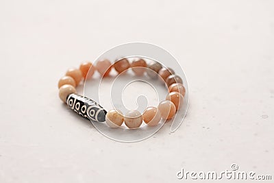Sun stone Dzi bead 21 eyes bracelet. Bracelet made of stones on hand from natural Sun stone. Handmade jewelry bracelets on light Stock Photo