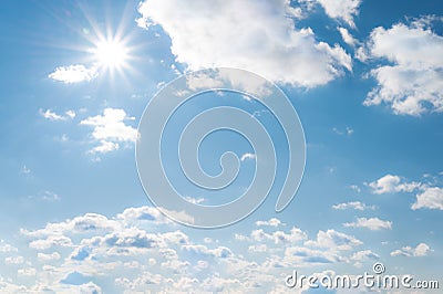 Sun with sunrays on the blue sky with white clouds. Daytime and good weather Stock Photo
