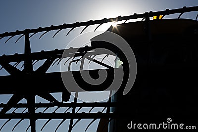 The sun at sunset against the background of the header and the cab of the combine. Concept Stock Photo