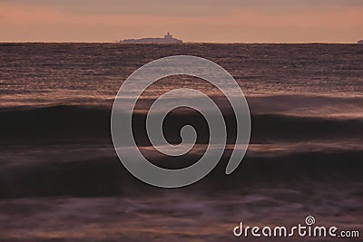 The sun is about to rise on the horizon, the sky and the sea take on warm colours Stock Photo