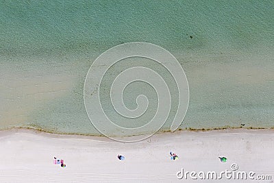 Sunbathers Laying Socially Distanced On Beach Foreshore Stock Photo