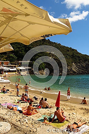 Sunbathers on sandy Mediterranean beach Greek island of Corfu. Editorial Stock Photo