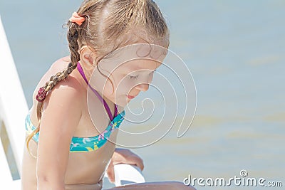 Sunbathing little girl kid on white plastic beach chair Stock Photo