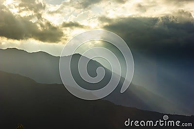 Sunbeam above mountains at sunset Stock Photo