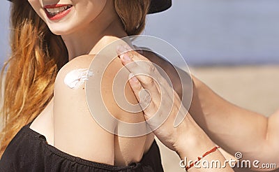 Suncare couple on a summer beach vacation have good skincare with high spf sunblock. Couple applying suncream. Stock Photo