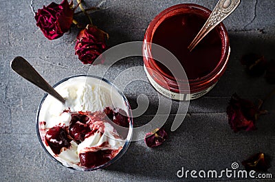 Sundae Ice cream with cherry in chocolate topping, and dried rose flowers on dark background. Love, Valentine`s day Stock Photo