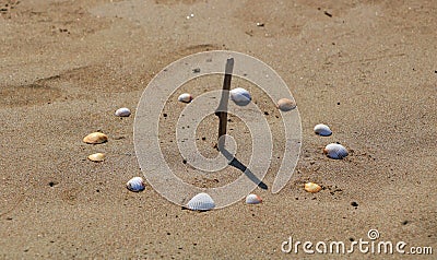 Sundial Made with Seashells on Beach, Close Up Stock Photo
