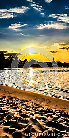 Sundown over the sandy Beach of the river Rhein in Cologne, Germany with cloudy sky and sand Stock Photo