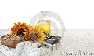 Sunflowers bottle of oil and seeds on wooden table against white background space for text Stock Photo