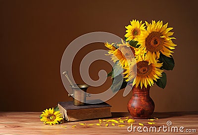 Sunflowers in a ceramic vase and books Stock Photo