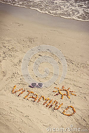 Sunglasses, inscription vitamin D and shape of sun on sand at beach Stock Photo