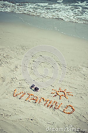 Sunglasses, inscription vitamin D and shape of sun on sand at beach, summer time and healthy lifestyle Stock Photo