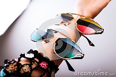 Fashionable sunglasses with multicolored lenses on hand Stock Photo