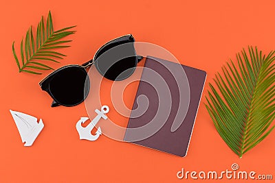 Sunglasses and passport decorate with fern leaves and tiny sailboat and anchor Stock Photo