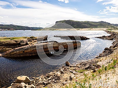 Sunken old wooden fishing boats in Teriberka, Murmansk Oblast, Russia Stock Photo