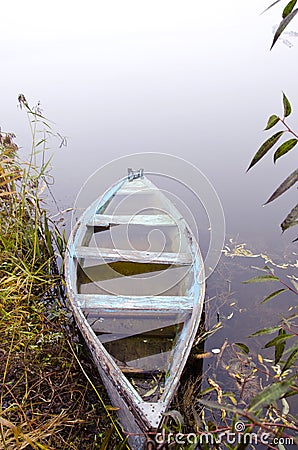 Sunken wooden boat with water stand on river shore Stock Photo