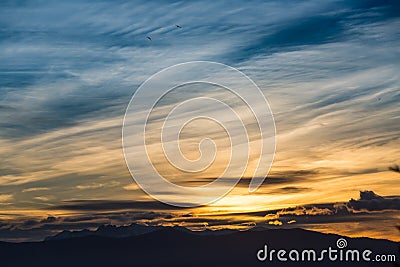 Sunlight behind dark mountain silhouettes Stock Photo