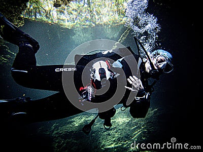 Sunlight illuminates a diver beneath the duckweed at Catfish Hotel in Manatee Springs State Park, Florida Editorial Stock Photo