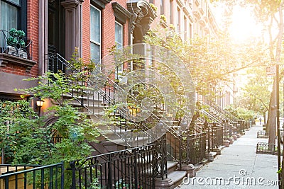 Sunlight shines on historic brownstone buildings in New York City Stock Photo