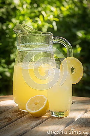 Sunlit jug and glass of fresh Corsican lemonade in garden Stock Photo