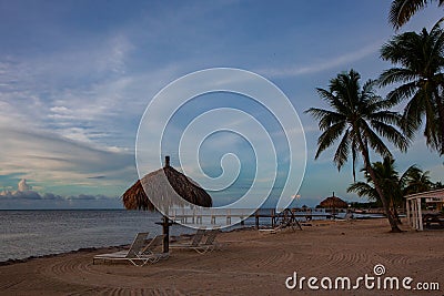 Sunlounge chairs and umbrella on the sunset beach in Florida Keys Stock Photo