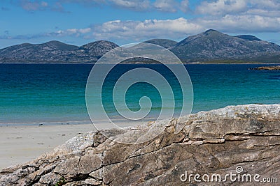 Sunny beach with sand dunes, tall grass and blue sky. Stock Photo