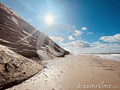 Sunny day on the beach between rocky coast and sea Stock Photo