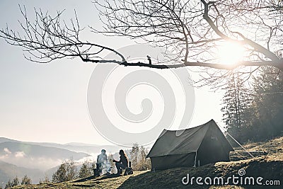 Sunny morning. Young couple having morning coffee while camping Stock Photo