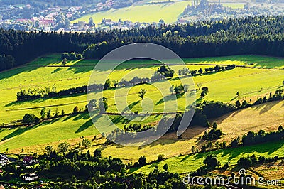 Sunny mountain valley with green fields and meadows. Scenic farmland landscape aerial view. Stock Photo