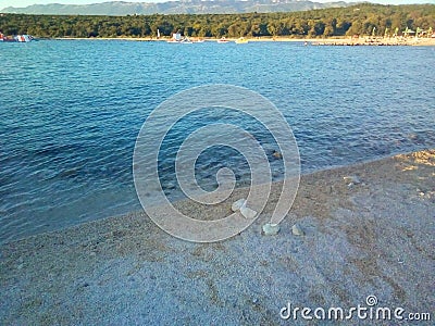 Abandoned stones on a sunlit shore. Stock Photo