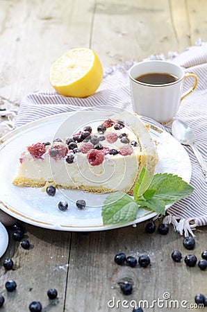 Sunny Photo with a morning breakfast in rustic style. Cheesecake raspberries and blueberries on wooden table. Stock Photo