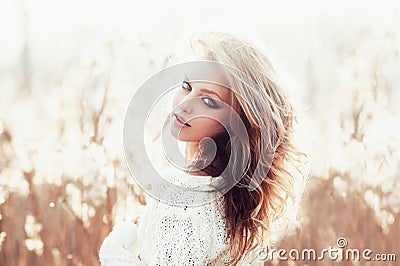 Sunny portrait of a beautiful young blonde girl in a field in white pullover, the concept of health and beauty Stock Photo