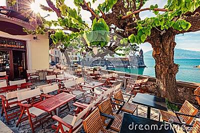 Sunny summer scene of outdoor cafe in Nafpaktos town. Colorful morning scene of Gulf of Corinth, Greece, Europe. Bright Mediterran Editorial Stock Photo
