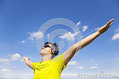 Sunny young man enjoying music with blue sky Stock Photo