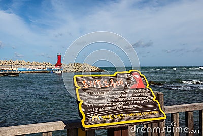 Sign of Bay with Lighthouse of Cape Ganjeolgot and Breakwater in background. Easternmost Point of Peninsula in Ulsan, South Korea Editorial Stock Photo