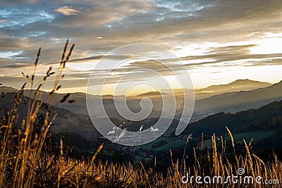 Sunrise in the austrian alps shining at a sleeping valley and mystic clouds in styria Stock Photo