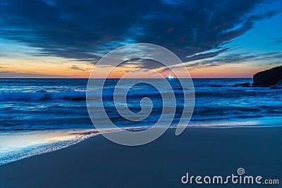 Sunrise at the beach with high cloud and boat with lights Stock Photo