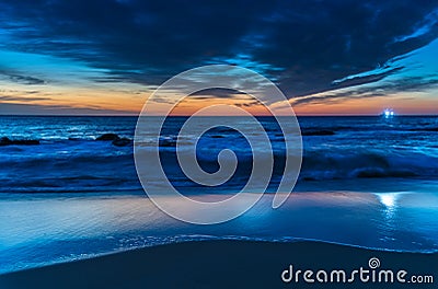 Sunrise at the beach with high cloud and boat with lights Stock Photo