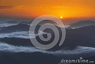 Sunrise on distant mountains with fog Stock Photo