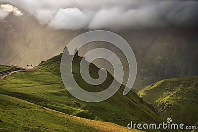 Sunrise at the Gergeti Trinity Church with sunrays of Kazbegi mountain in Georgia Stock Photo