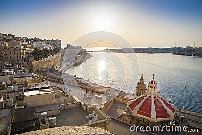 Sunrise at the Grand Harbour of Malta with the ancient walls of Valletta Stock Photo